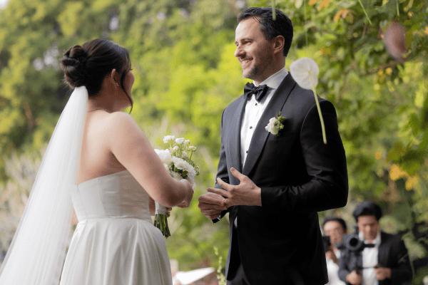 Bride and groom exchanging vows outdoors in a wedding ceremony.