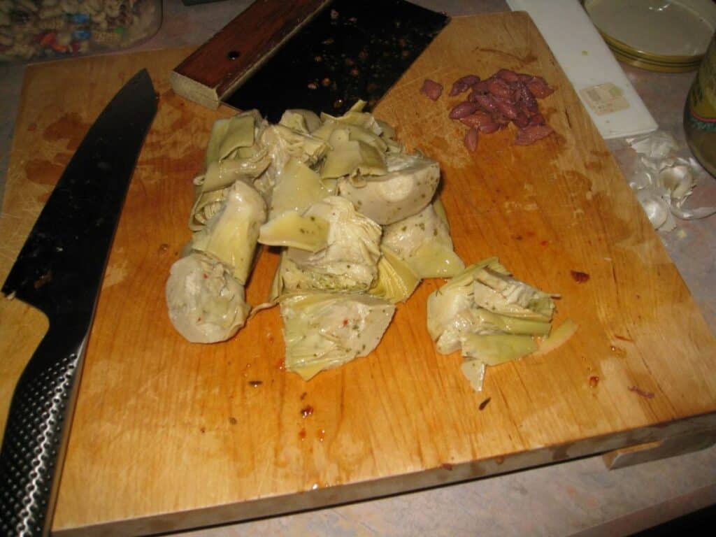 Image shows artichokes on chopping board.