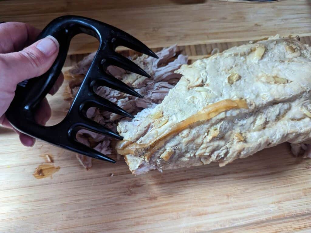 Shredding garlic pork roast.