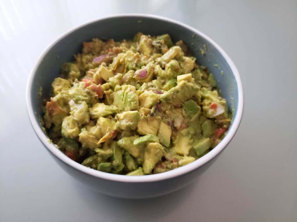Image shows chunky guacamole in a bowl.