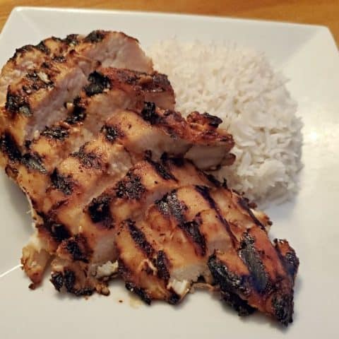 Miso glazed chicken with rice on a white plate.