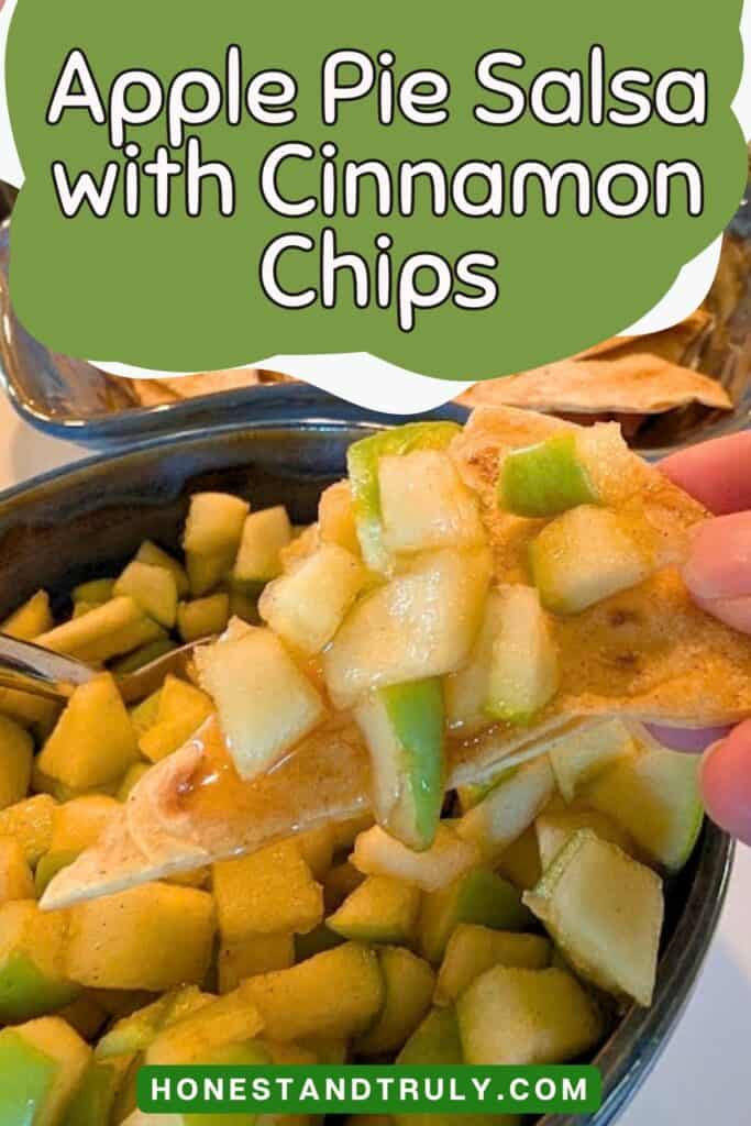 A hand holds a cinnamon chip topped with apple pie salsa over a bowl of the same mixture. Text overlay reads: &ldquo;Apple Pie Salsa with Cinnamon Chips.&rdquo;.