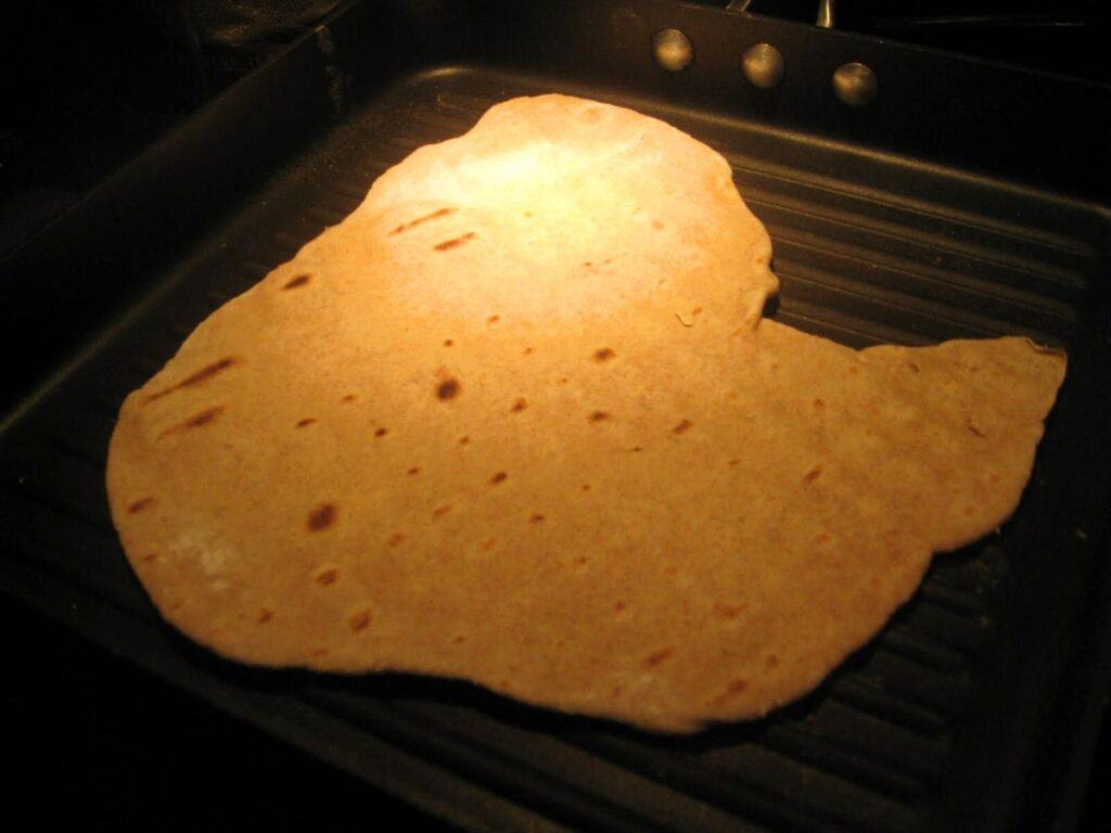Image shows grilled flatbread dough.
