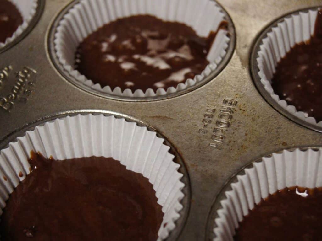 Image shows chocolate cinnamon cupcakes batter in cupcake pan.