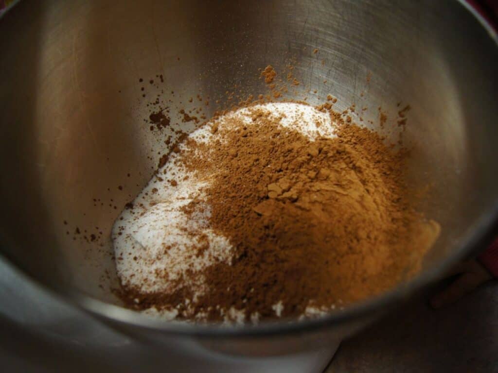 Image shows dry ingredients for chocolate cinnamon cupcakes in a large bowl.