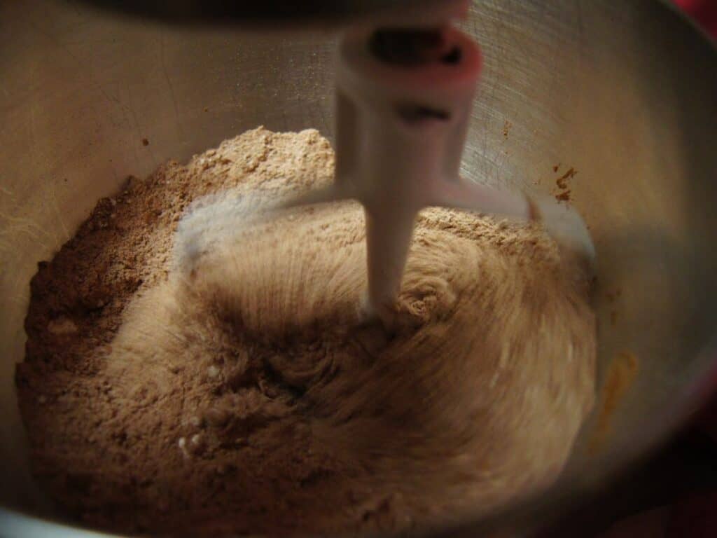 Image shows dry ingredients for chocolate cinnamon cupcakes whisked in the bowl.