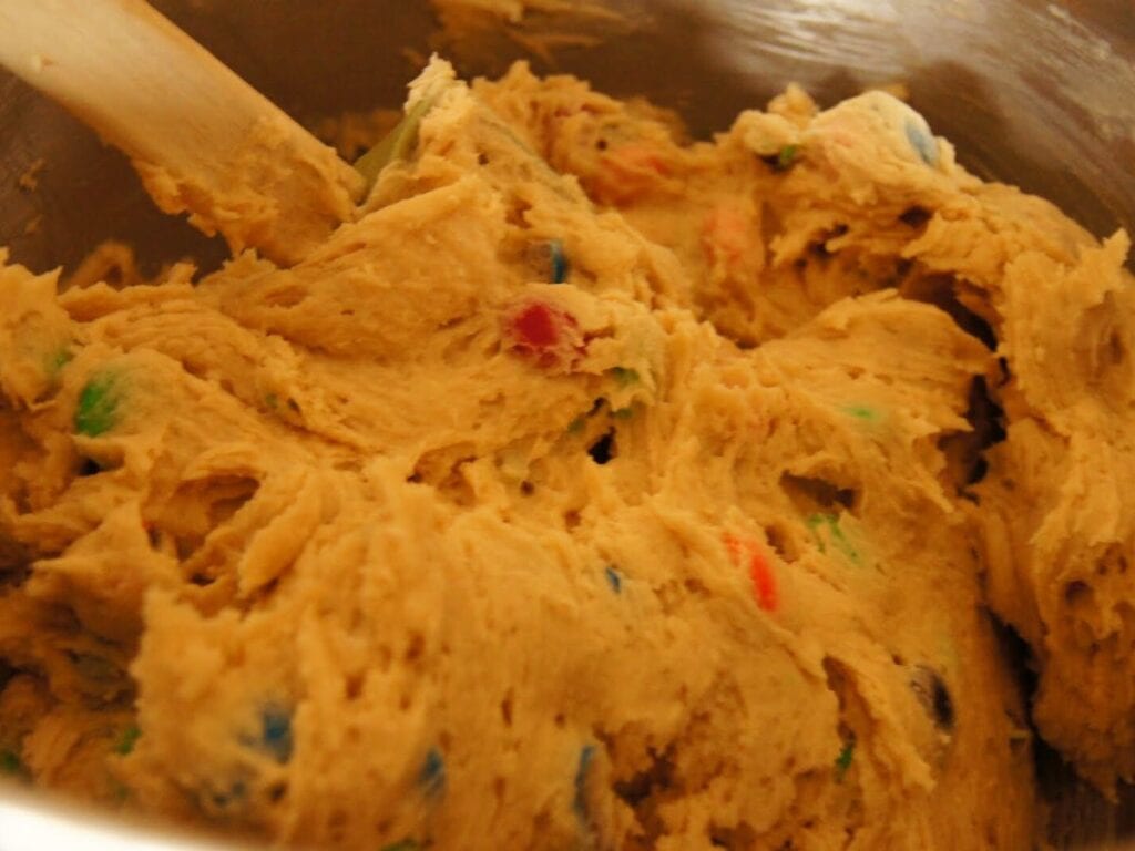 Image shows M&Ms added to the cookie dough.