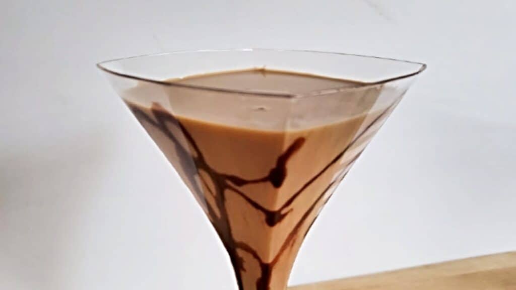 Chocolate martini in a square glass with a white background.