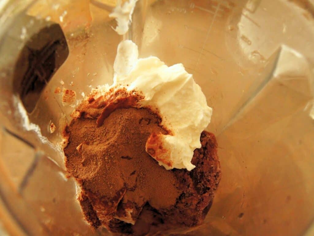Image shows ingredients of chocolate cherry smoothie in the blender.