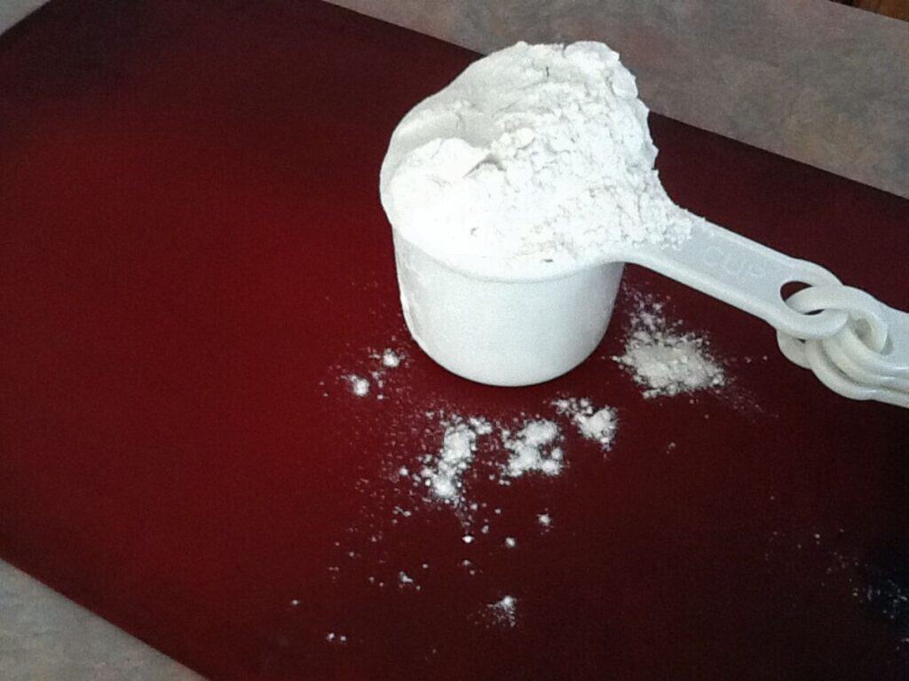 Image shows heaping amount of flour in a measuring cup.