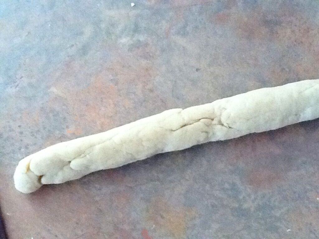 Image shows kneading pasta dough by rolling.