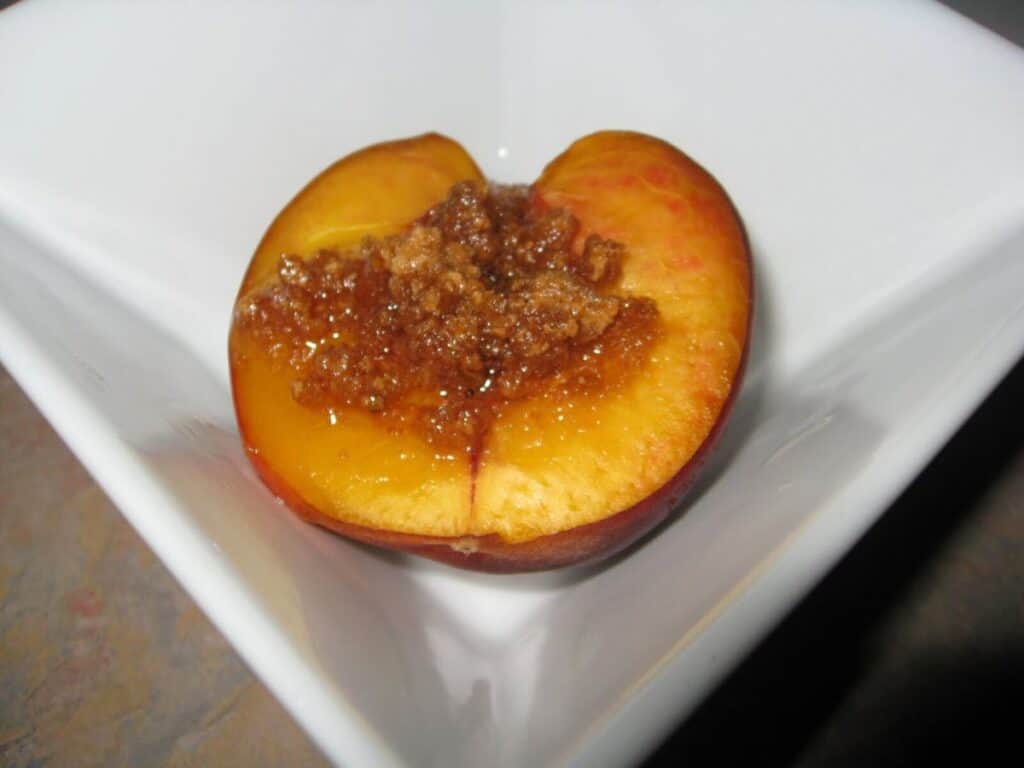 Image shows baked peach on a serving plate.