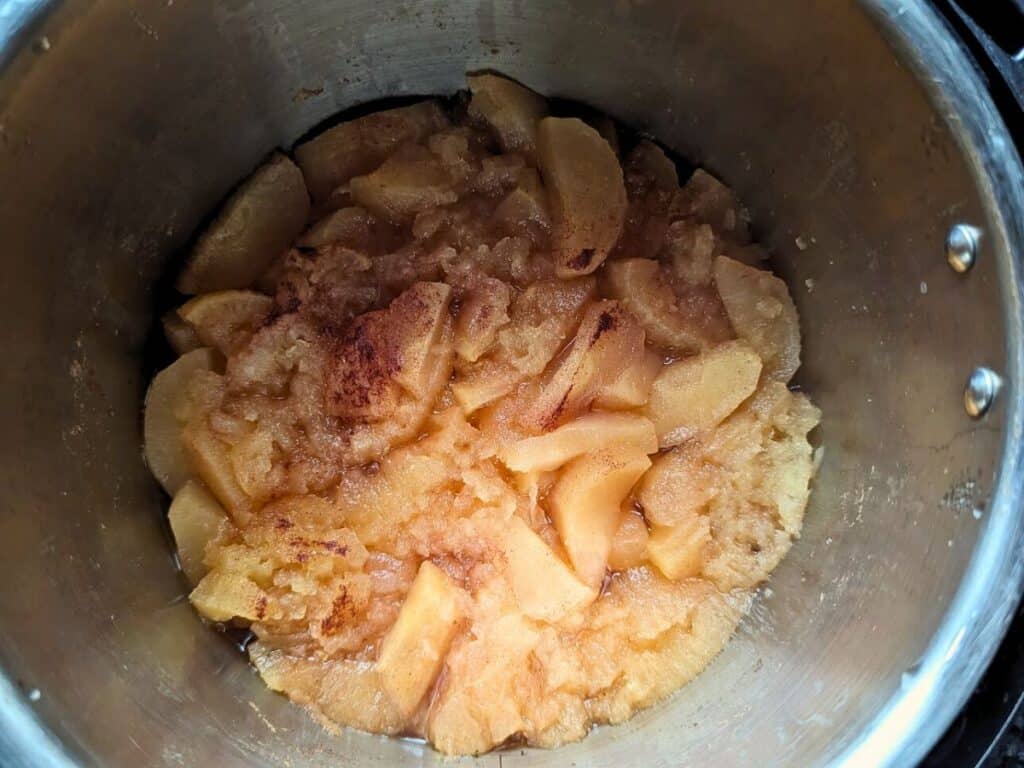 Image shows almost cooked applesauce.