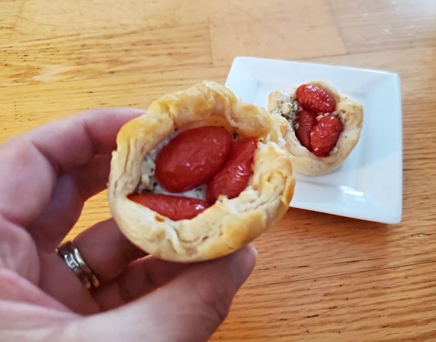 Hand holding a tomato appetizer