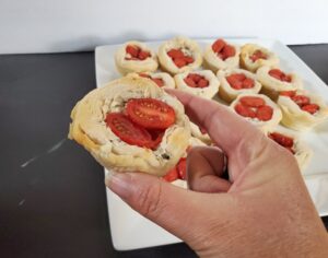 Holding a tomato basil cup over a tray of more of them
