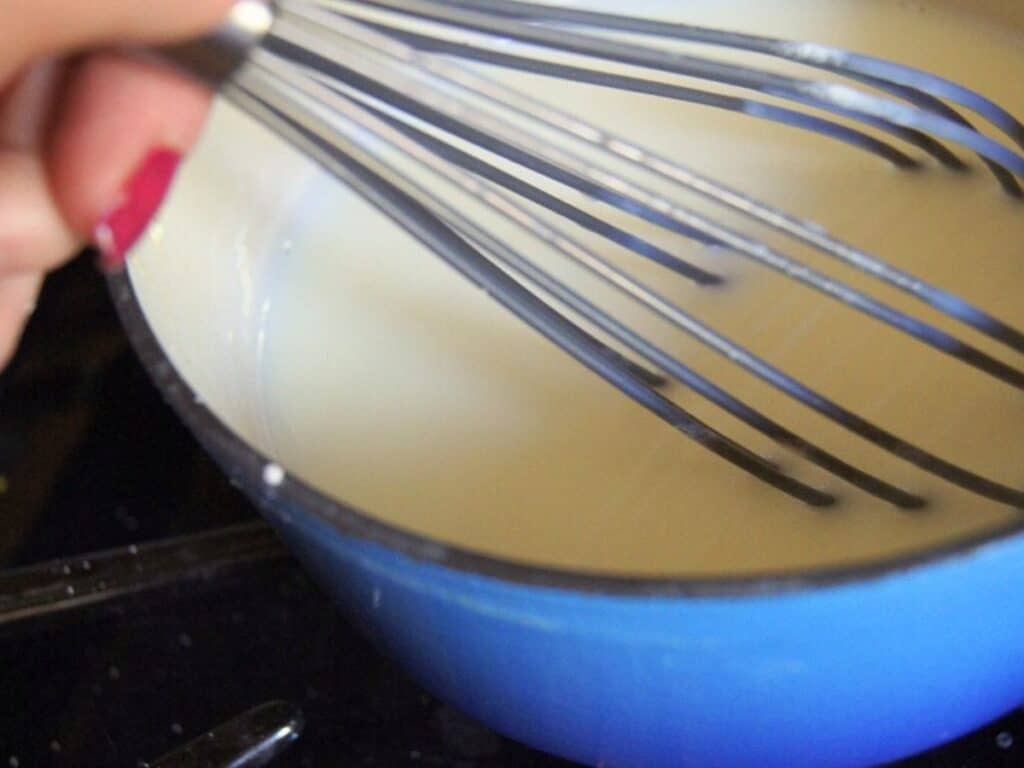 Image shows homemade vanilla pudding starting to thicken.