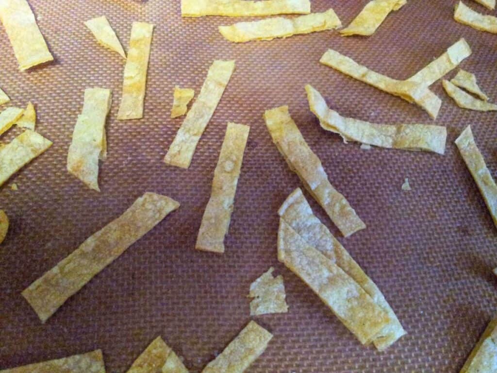 Image shows baked tortilla cut in strips.