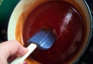 Image shows homemade BBQ sauce in a saucepan.