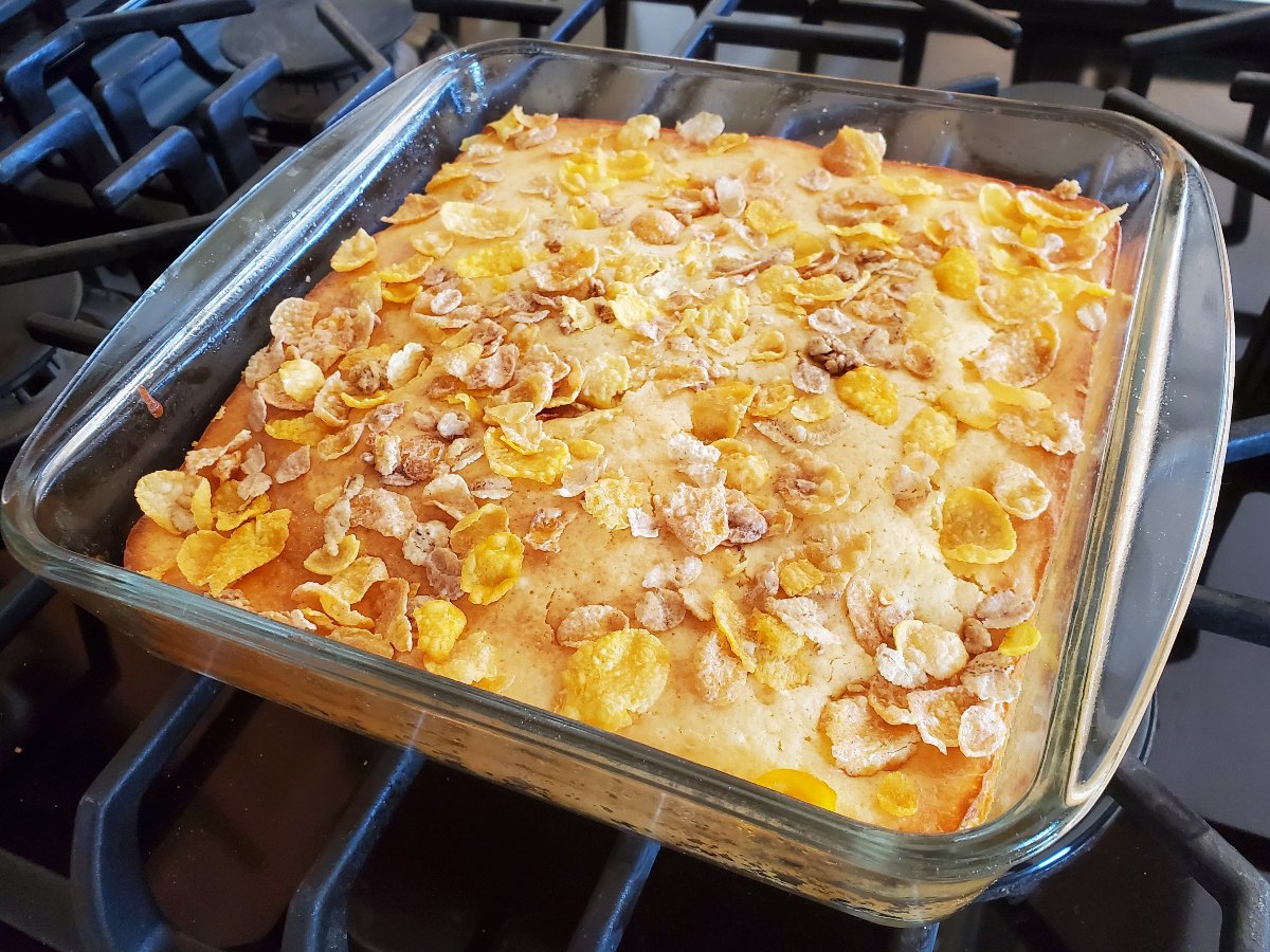 Image shows A freshly baked vanilla orange cheesecake bars pan in a glass dish.