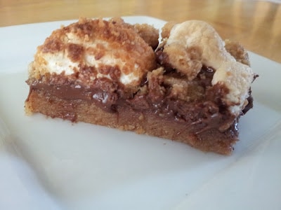 Slices of a chewy s'mores bar sitting on a white plate.