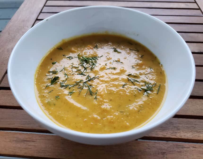 Delicious bowl of carrot ginger soup with dill on top