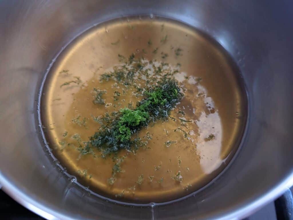 Image shows an overhead shot of Tropical fruit salad simple syrup in a pot.
