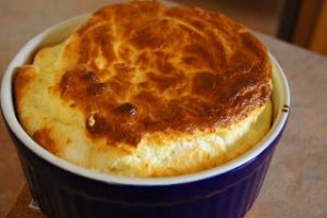 Cheese Souffle in an individual blue ramekin.