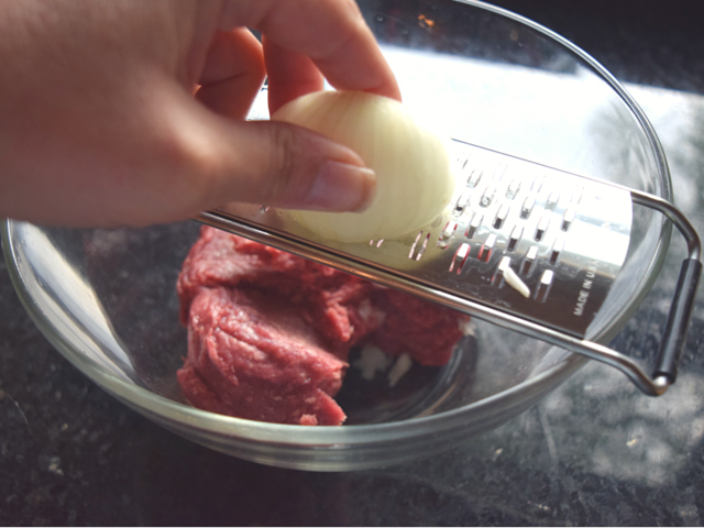 Grating onion into chipotle burgers