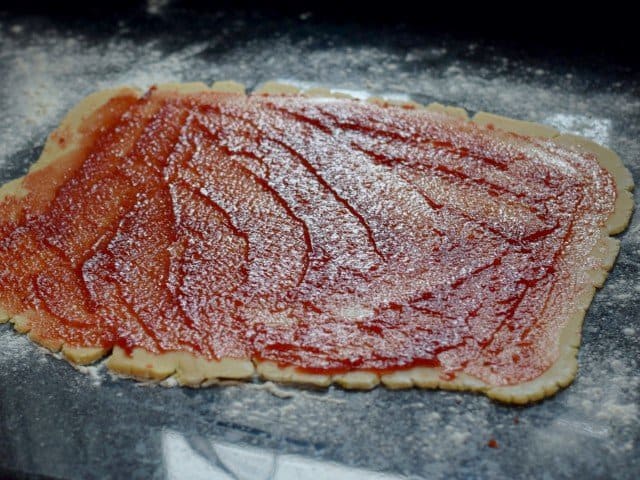Spread cherry preserves over the dough rectangle