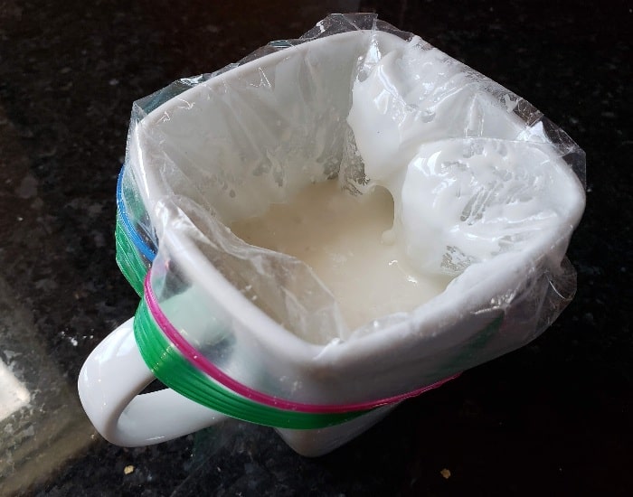 Put icing bag in a cup to hold it
