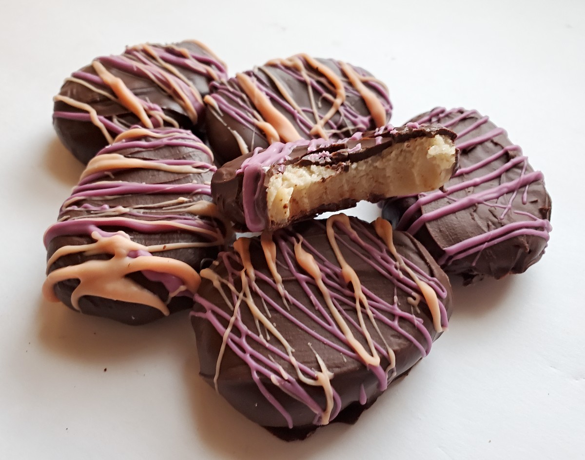 Image shows a cluster of easter egg truffles with one missing a bite and showing the cookie dough inside.
