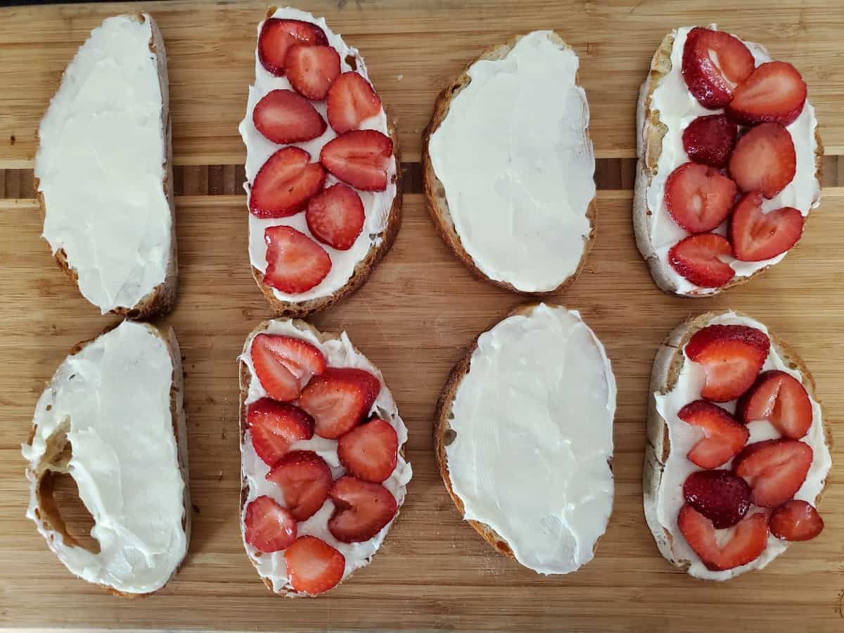 Strawberry french toast ready to assemble into sandwiches on a wooden background.
