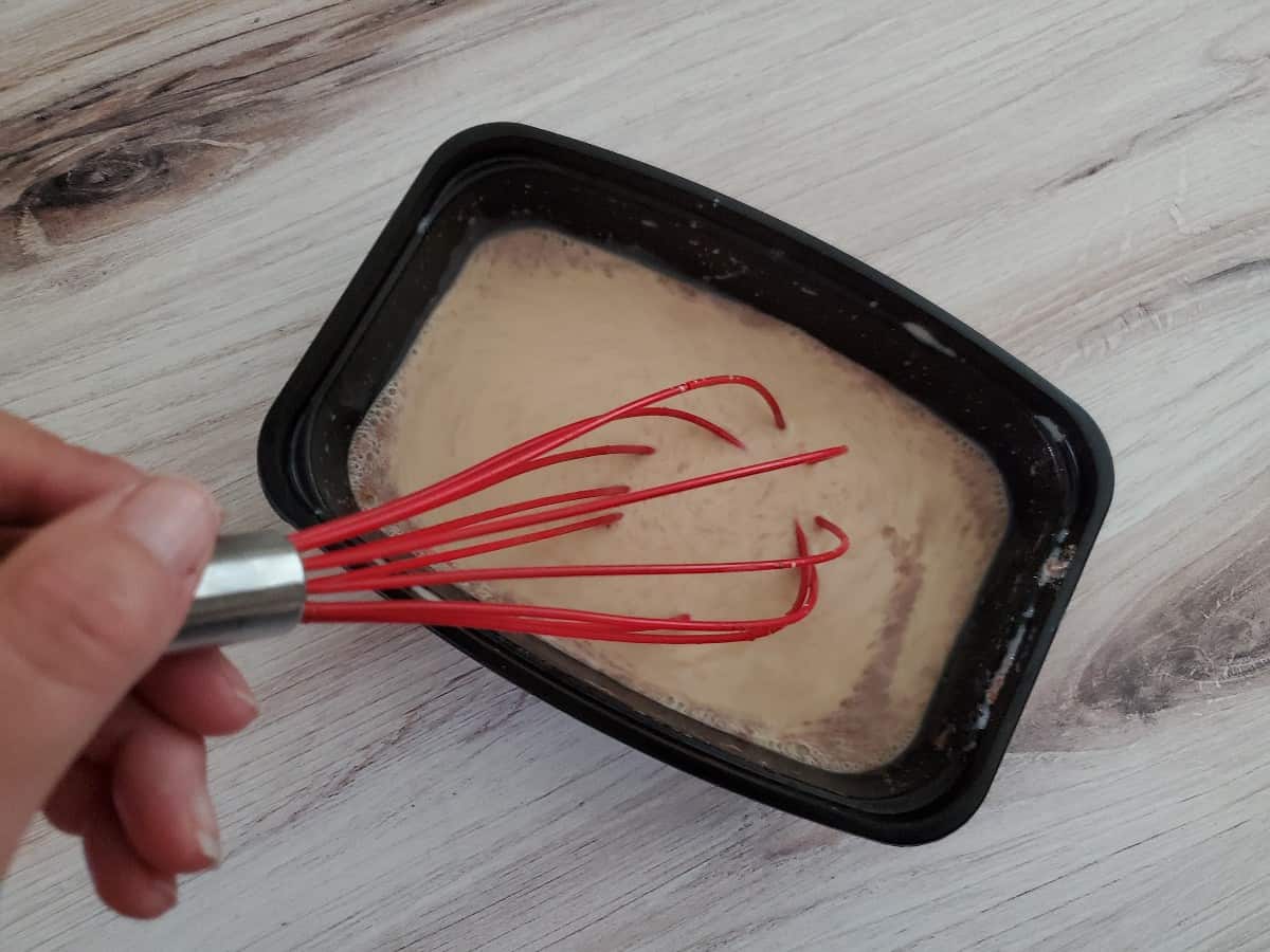 Whisking egg mixture in a black container.