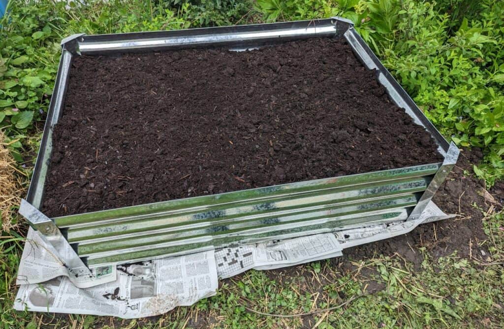 Raised garden bed filled with soil.