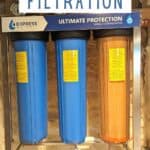 Image shows Installed water filtration sytem with text whole house filtration.