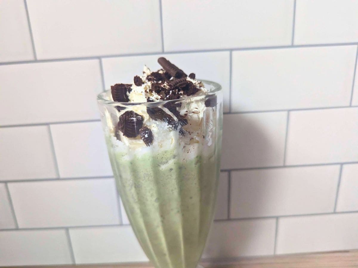 Image shows a Closeup of a peppermint oreo shake in a glass.