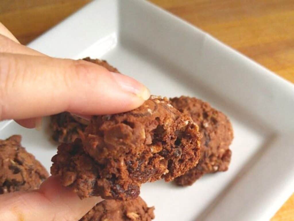 Image shows bite of irresistible chocolate raisin cookies.