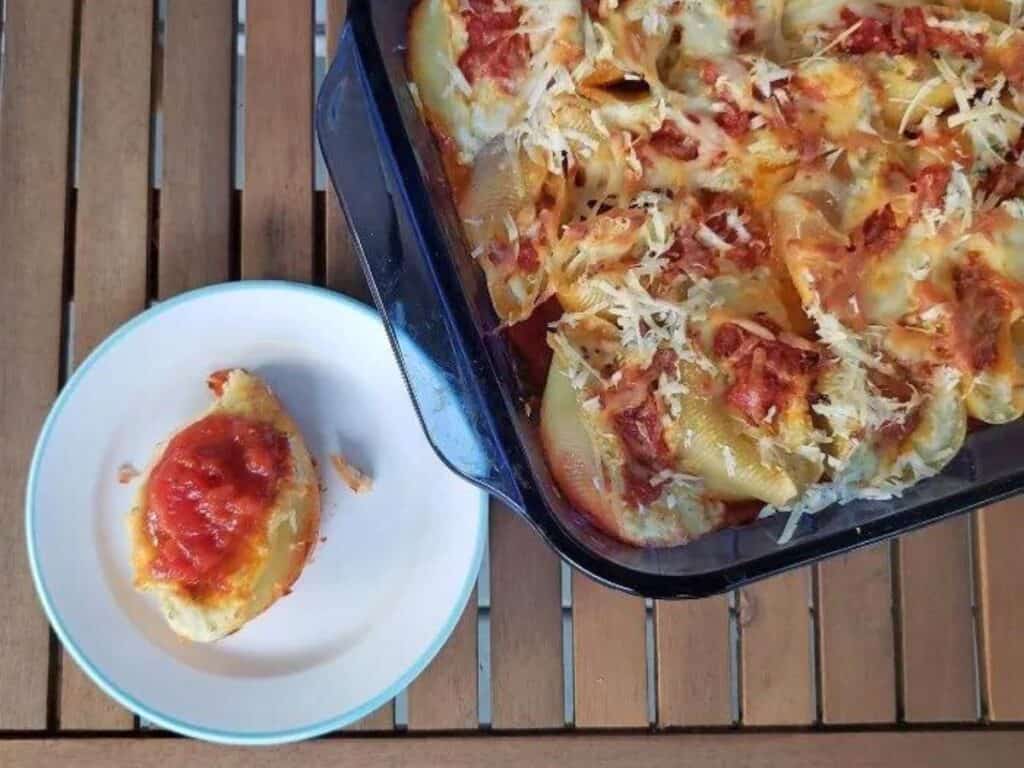 Image shows cheesy stuffed shells served on a plate.