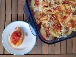 Image shows cheesy stuffed shells served on a plate.