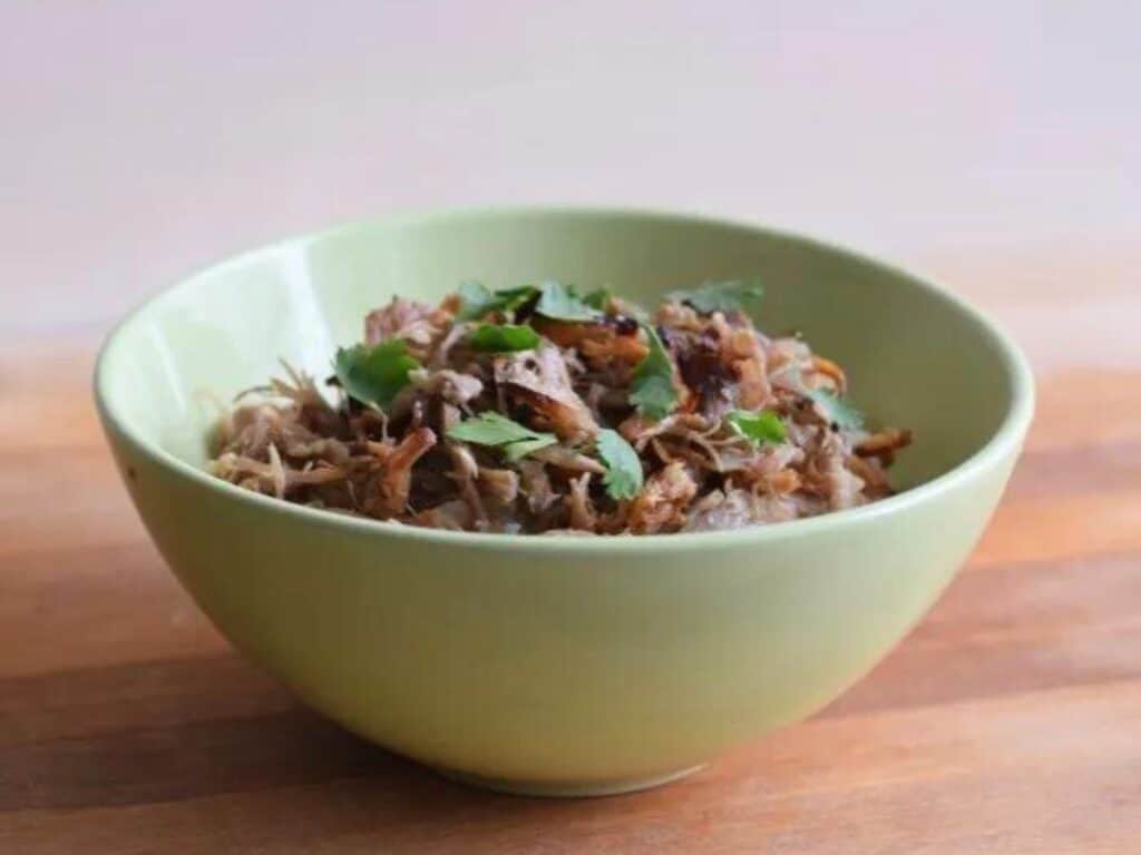 Image shows crispy carnitas in a bowl.
