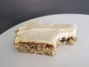 Image shows delicious bite of frosted banana bars.