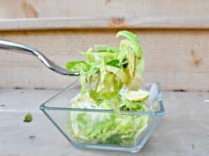 Image shows delicious shaved brussel sprout salad on a fork.