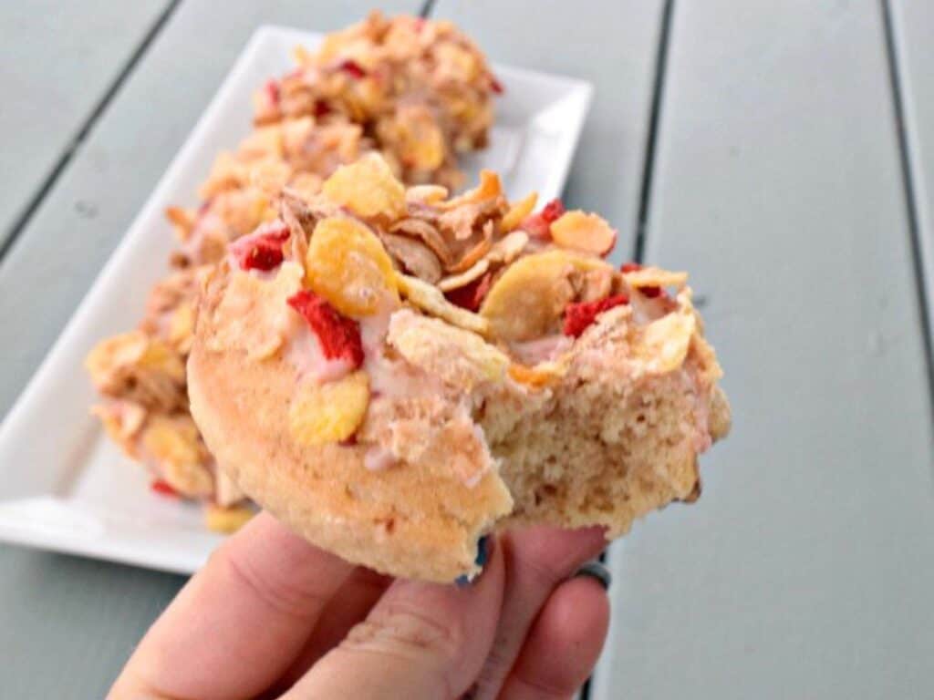 Image shows delicious strawberry cereal donut.
