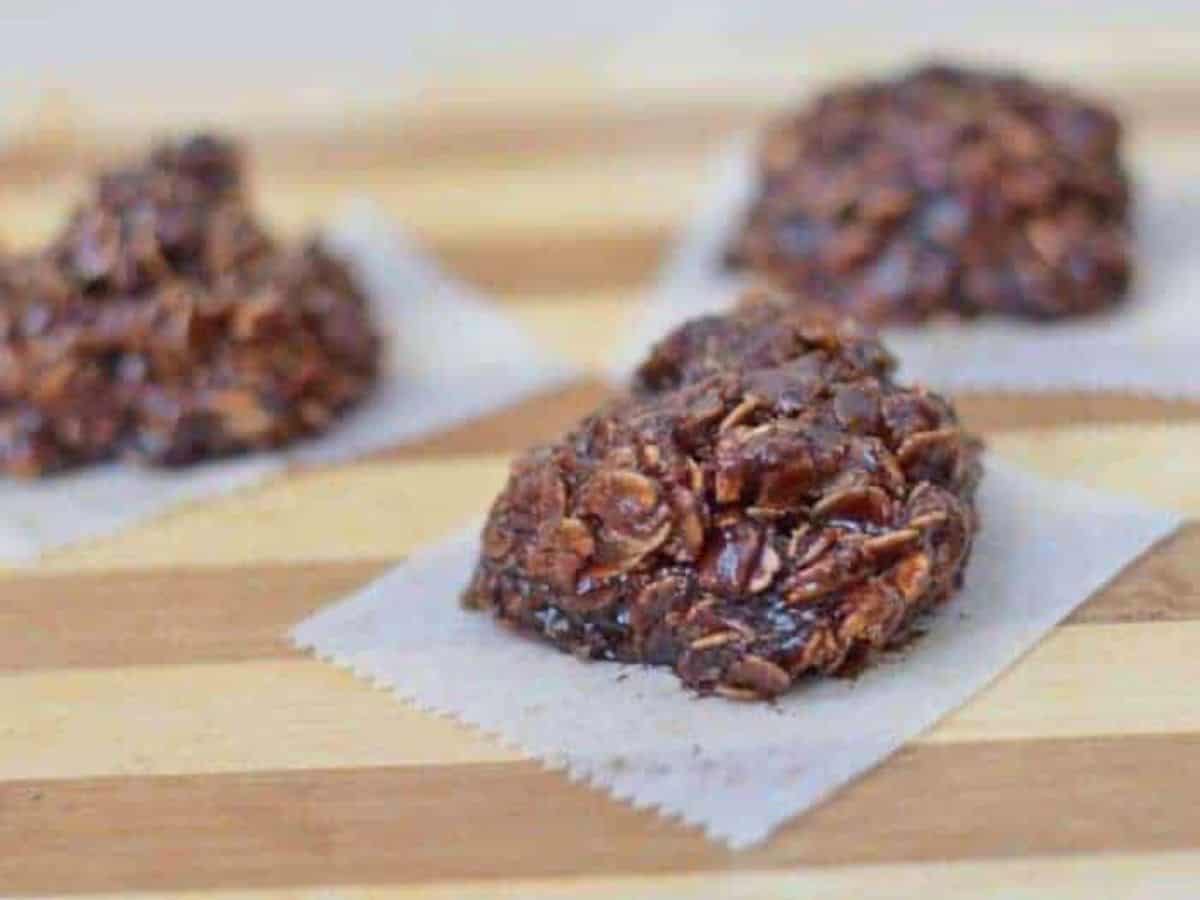 Image shows no bake nutella cookies on wax paper sitting on a wooden board.