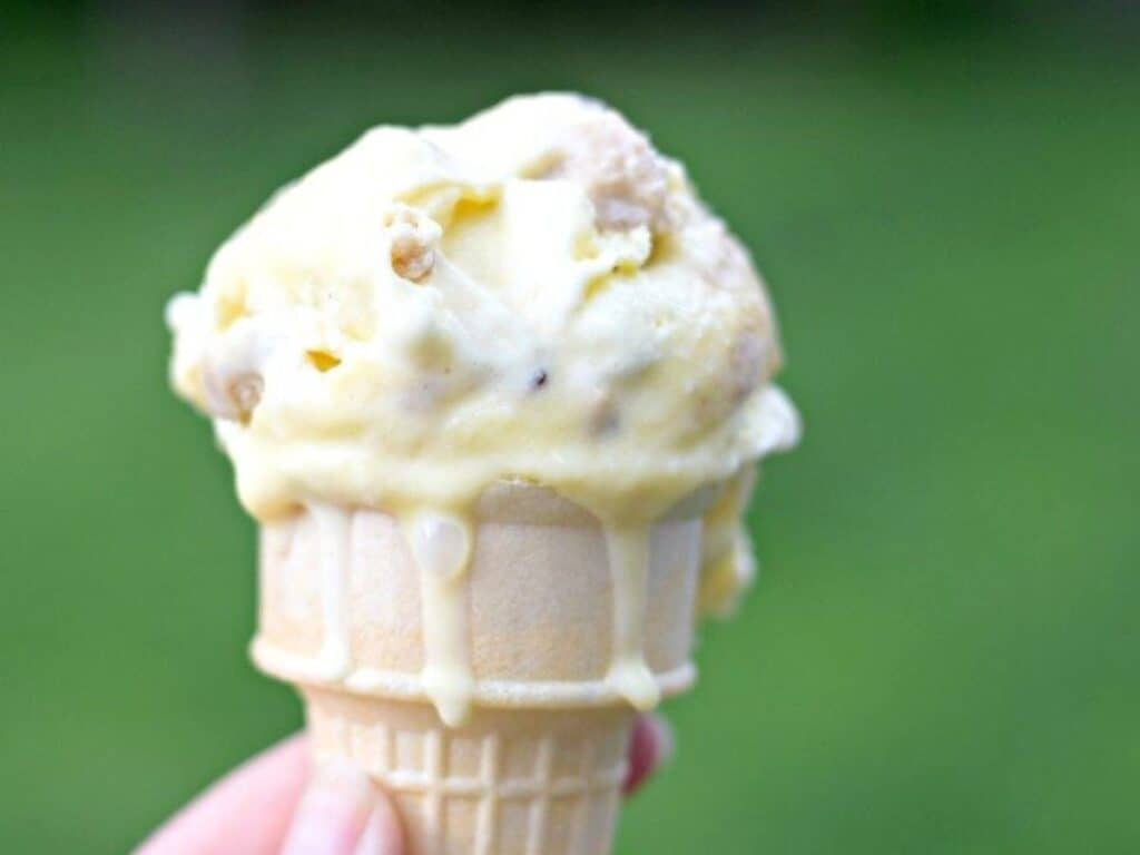 Image shows homemade cookie dough frozen custard on a cone.