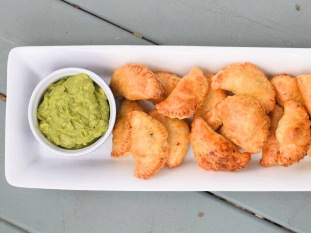 Image shows serve and ready to eat puff pastry beef empanadas.