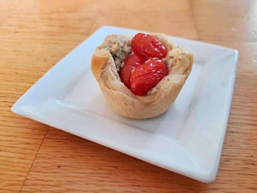 Image shows tomato basil cup served on a plate.