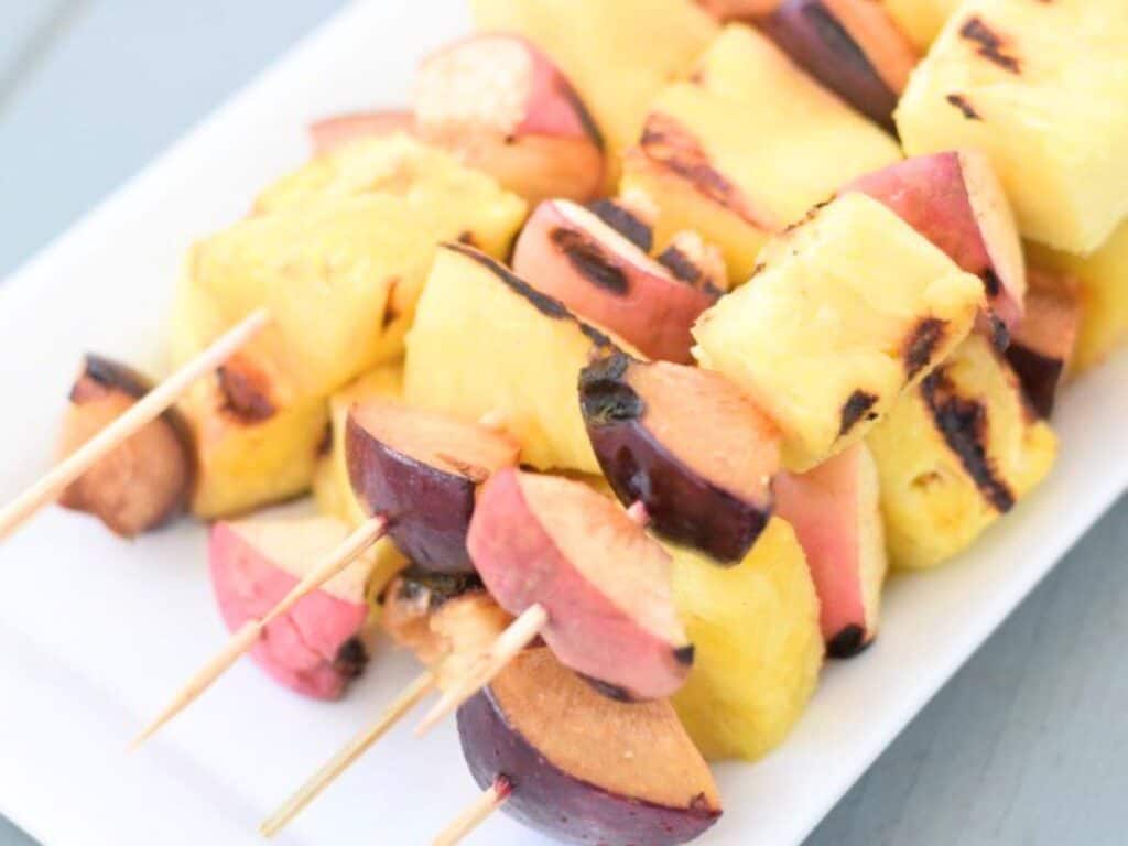Image shows yummy platter of grilled fruit kebabs.