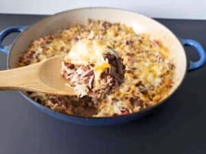 Image shows spoonful of easy to make cheesy beef and rice casserole.