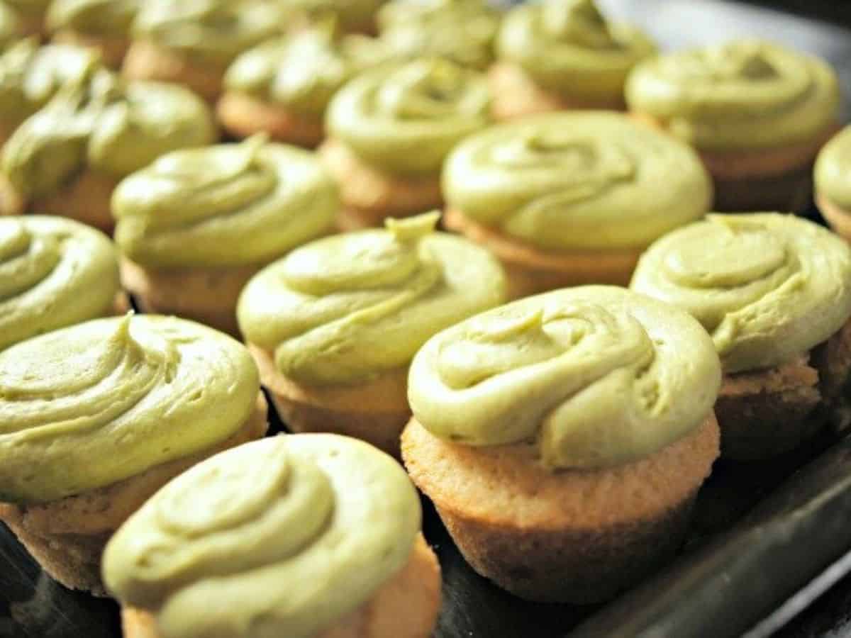 Image shows A tray of green tea cupcakes with matcha frosting on them.